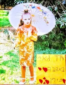 ילדה עם מטריית נייר צבעונית וברכה בכתב יד בתמונה מעוצבת
