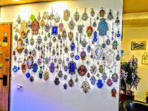 קיר מכוסה בעשרות חמסות מעוצבות בכניסה למרפאה