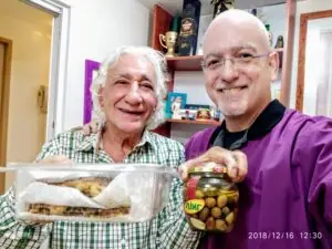 שני גברים מחייכים מציגים מארז מזון וצנצנת חמוצים